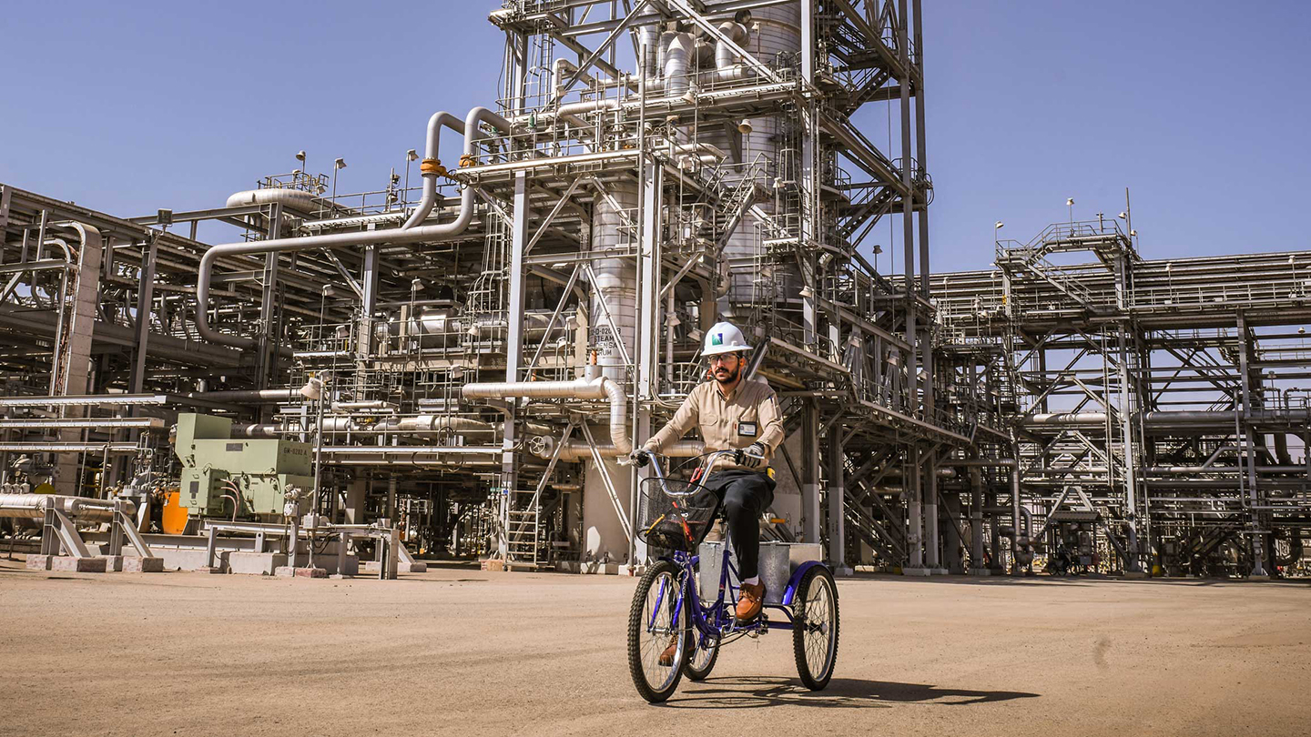 Aramco employee on tricycle at renewables plant