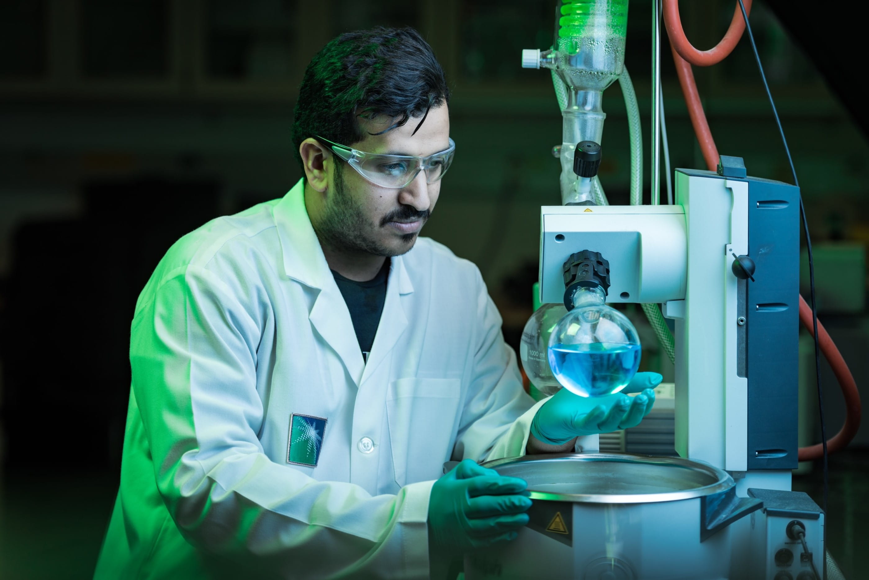 Aramco chemical lab technician testing blue liquid