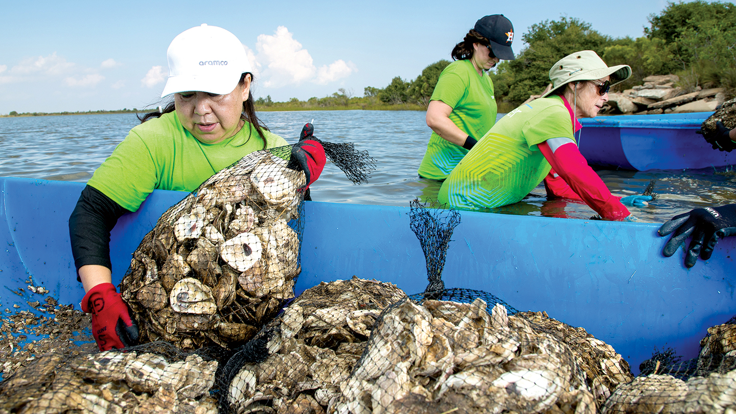 Three women bagging recycled oyster shells