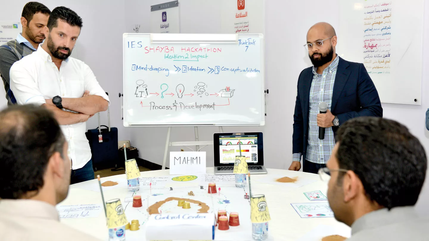 Workshop team discuss in front of a whiteboard